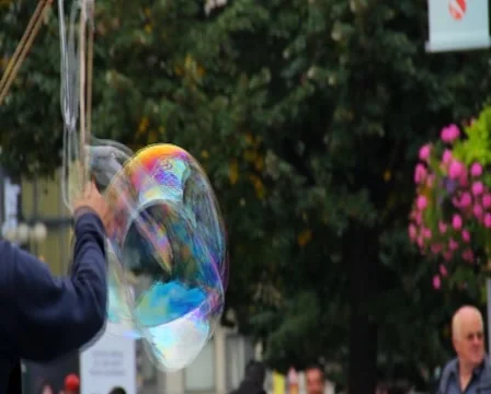 Soap bubbles on the street, huge bubble flying near people, click for HD Stock Footage 43895600