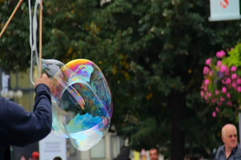 Soap bubbles on the street, huge bubble flying near people, click for HD Stock Footage 43912619
