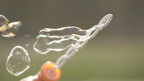 Soap bubbles in sunset light. Happy family blowing soap bubbles in park. 库存影片 99490225