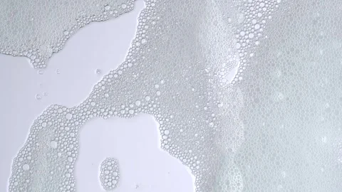 Soap bubbles on window glass. Macro shot of white soap suds flowing down of.. Stock Footage 269324151