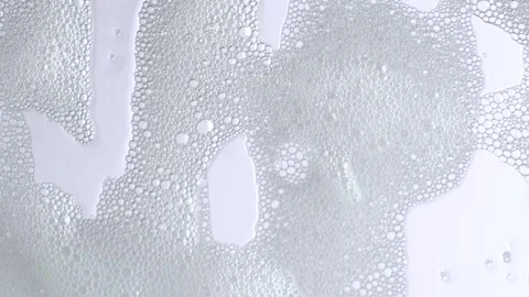 Soap bubbles on window glass. Macro shot of white soap suds flowing down of.. Stock Footage 275143848