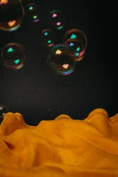 Soap bubbles on yellow black background Stock Photos