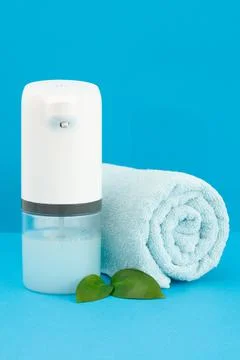 Soap dispenser automatic. In the background is a blue towel. Close-up. Blue b Stock Photos