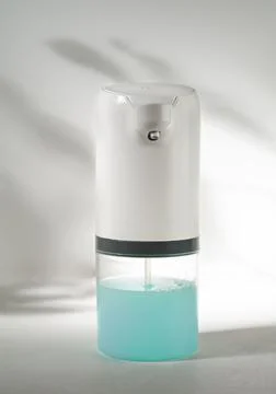 Soap dispenser automatic. Close-up. Gray background with shadow. Stock Photos