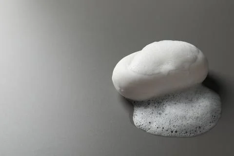 Soap with fluffy foam on grey background, space for text 스톡 사진