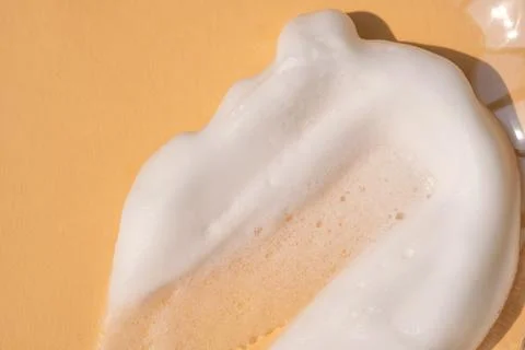 Soap foam on a light beige background. Stock Photos