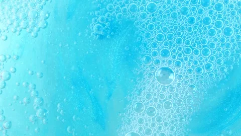 Soap foam moving in blue shower gel background. Shampoo bubbles rotating. T.. Stock Footage 276411241