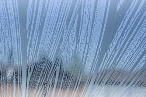 Soap foam pattern and bubbles on glass, houses background. Foto stock