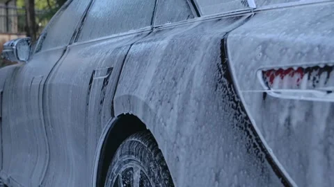 Soap foam slides down on modern luxury car body during professional detaili.. Stock Footage 337384562