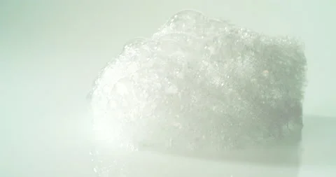 Soap lather falling onto a white surface Stock Footage 153152728