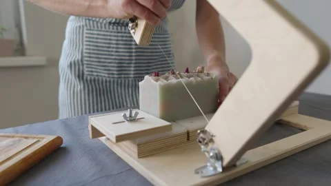 The soap maker cuts handmade flower soap on a wooden cutter Stock Footage 282154616