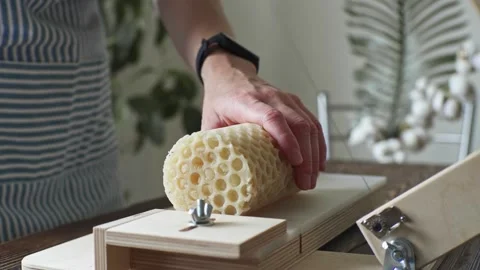 A soap maker cuts a round handmade honey soap on a wooden cutter Stock Footage 277873157