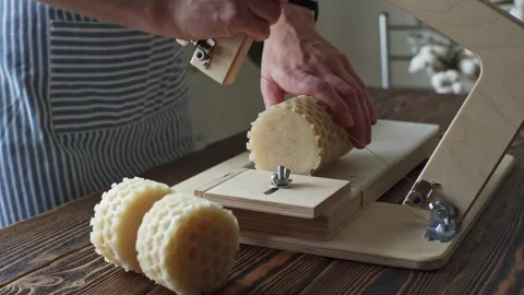 A soap maker cuts a round handmade honey soap on a wooden cutter Stock Footage 277873201