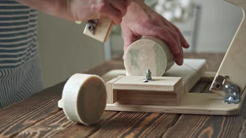 Soap maker cuts a round handmade soap on a wooden cutter.  Stock Footage 277873254