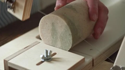 Soap maker cuts a round handmade soap on a wooden cutter.  Stock Footage 277873294