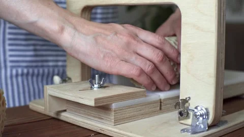 A soap maker cuts a round handmade honey soap on a wooden cutter Stock Footage 277876424