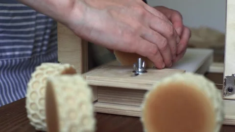 A soap maker cuts a round handmade honey soap on a wooden cutter Stock Footage 277876439