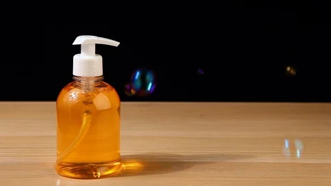 Soap plastic bottle bubbles wooden table dark background nobody hd footage Stock Footage 99981206