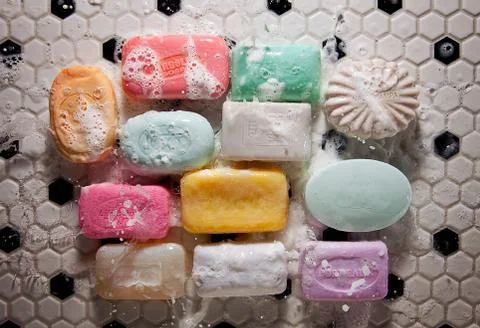 Soaps on bathroom floor with splash Stock Photos