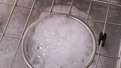 Soapy water drips down the sink drain in slow motion Stock Footage 306413075