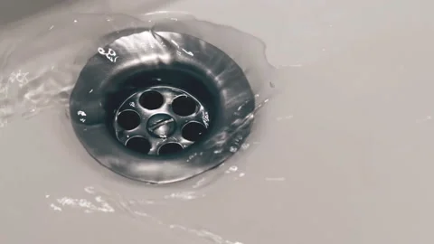Soapy water flowing down the drain of a sink in the bathroom Stock Footage 104672473