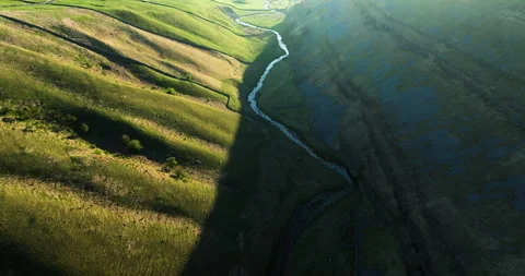 Soaring above a river in a sunny valley Stock Footage 335285782