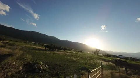 Soaring from field over barbed wire fence to farm land in FPV Video stock 248162047