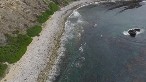 Soaring Over Rocky Coastal Waves on Private Beach Stock Footage 339711531