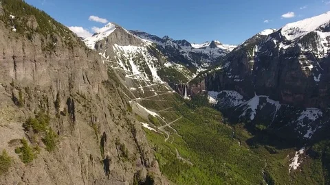 Soaring Past Gigantic Cliffs Over Valley Towards Mountains in Colorado Stock Footage 77714277