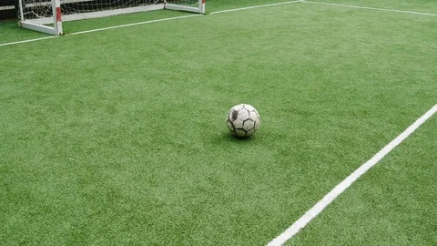 A soccer ball on an artificial lawn in front of the goalpost Stock Footage 95487553