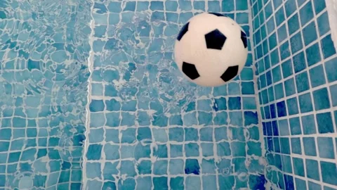 Soccer Ball Falling Into Swimming Pool in Dramatic Slow Motion Stock Footage 346555679