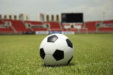 Soccer ball on the field of empty stadium Stock Photos