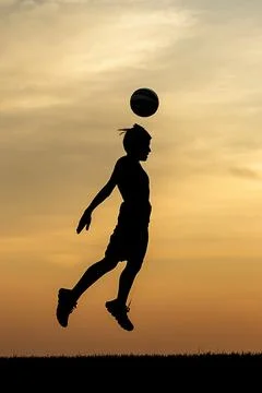 A soccer ball header at sunset. Stock Photos