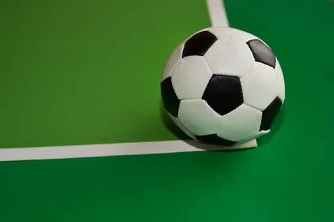 Soccer ball on intersection of white lines on green background, soccer ball o Stock Photos
