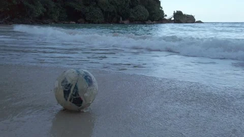 SOCCER BALL ROLLING ONTO BEACH Video stock 145297353