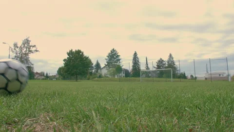 Soccer ball rolling from left to right on an empty soccer field Stock Footage 153378011