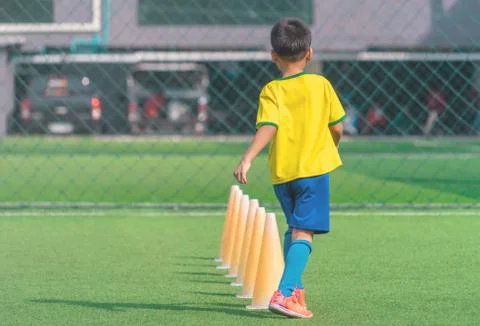 Soccer Boy is training alone with cone on training ground Stock Photos