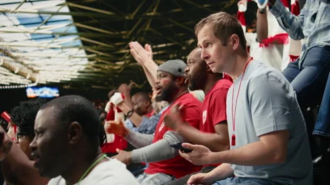 Soccer fan using betting app at the stadium during dramatic football match Stock Footage 335676161