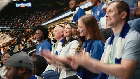 Soccer fans cheering and clapping during live football match in stadium stands Stock Footage 335674898