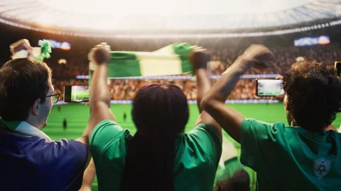 Soccer fans using smartphones to record match played on football field Video stock 337554399