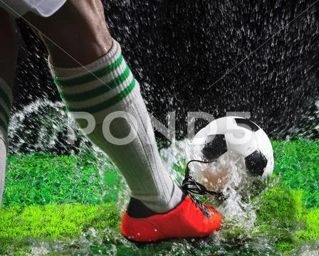 Soccer football players kicking to soccer ball on green grass field with spla Stock Photos