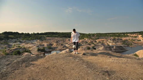 Soccer freestyler doing ball tricks on top of a mountain Stock Footage 133570670