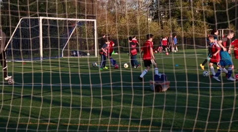 Soccer gate net, soccer training, grass field, teens kicking soccer balls Stock Footage 56249259