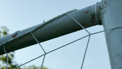 Soccer goal post holds white net under clear blue sky Stock Footage 336935573