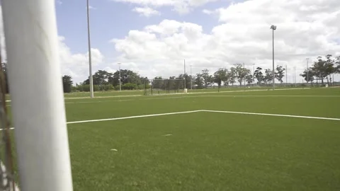Soccer net close-up showing empty field on sunny day Stock Footage 307584397