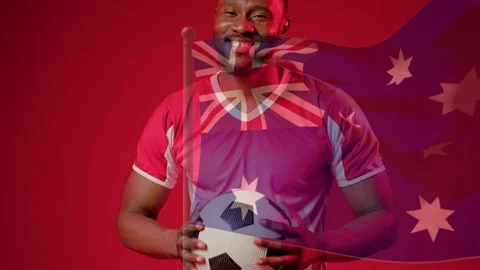 Soccer player catching ball in red set, causing flag overlay across chest and Stock Footage 333220177