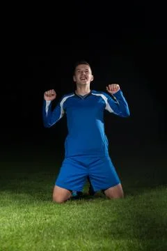 Soccer player celebrating the victory on black background Stock Photos