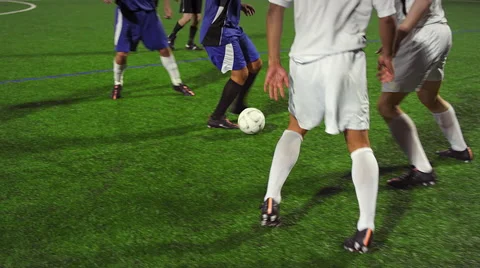 A soccer player dribbles down the field during a game at night Stock Footage 56196730