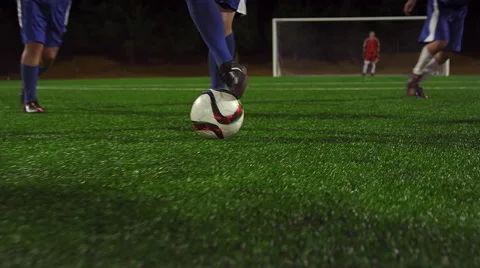 A soccer player dribbles down the field during a game at night Vídeo Stock 56197785