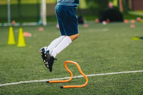 Soccer Player Jumping on Training Session Pitch. Football Training Equipment Stock Photos